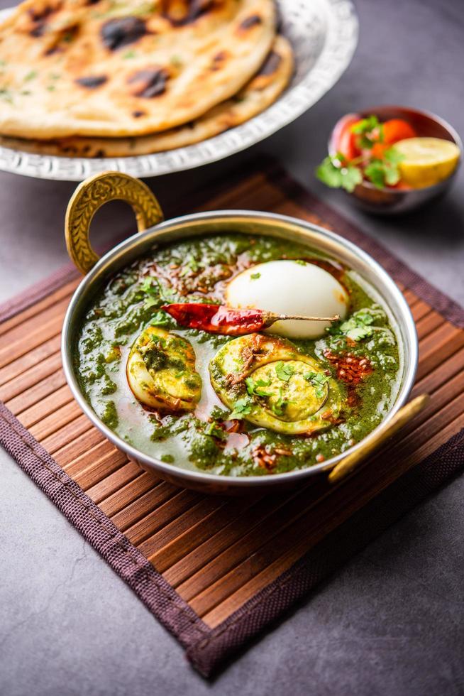 spenat ägg curry är ett indisk icke vegetarian maträtt tillverkad använder sig av palak skysås med ägg foto