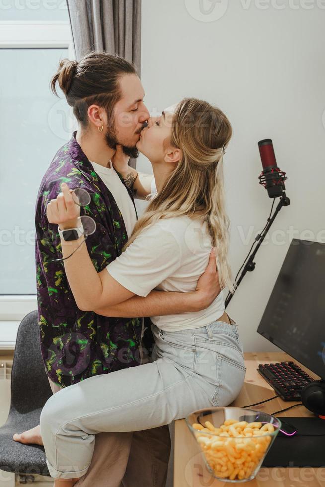 ung par kissing på de tabell med gaming personlig dator foto