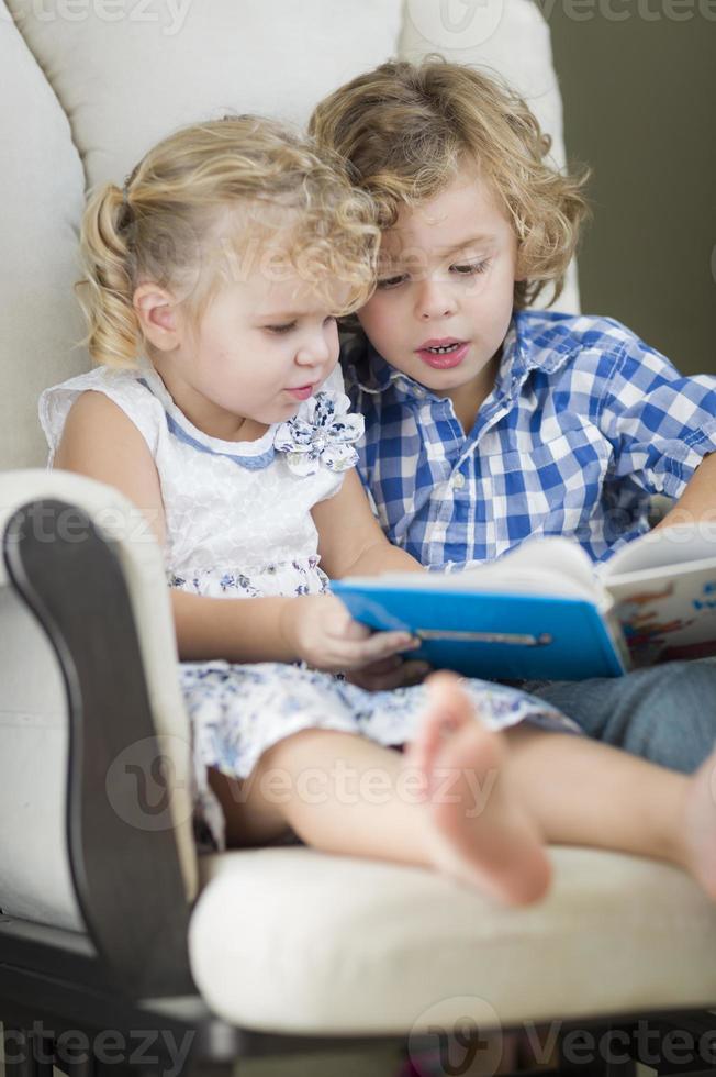 ung bror och syster läsning en bok tillsammans foto