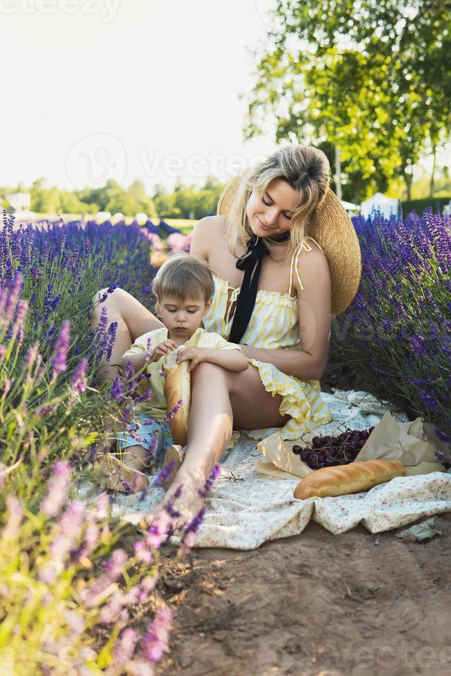 skön kvinna och henne söt liten son i de lavendel- fält foto