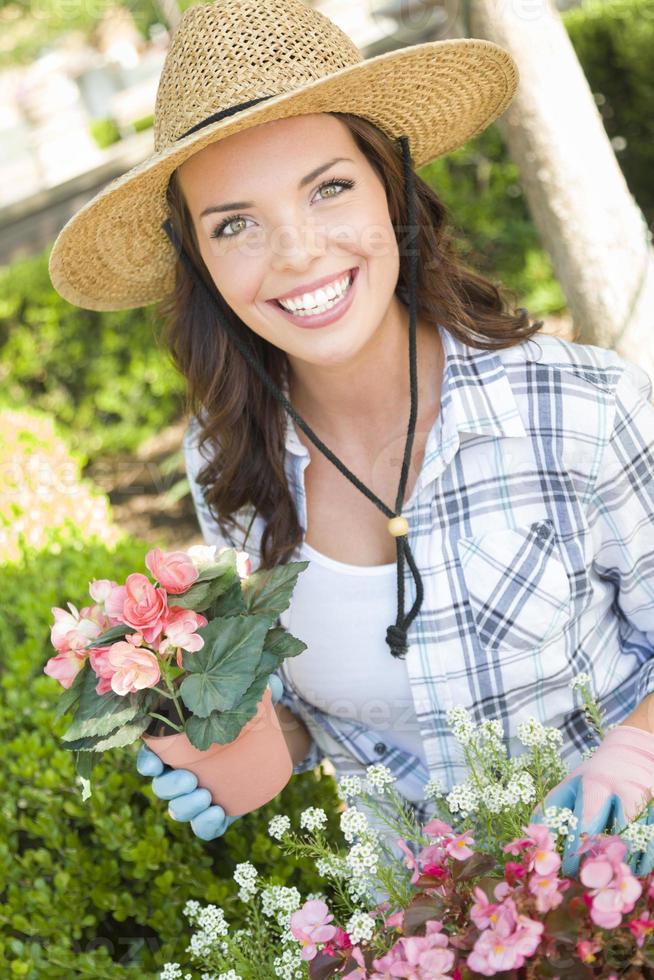 ung vuxen kvinna bär hatt trädgårdsarbete utomhus foto