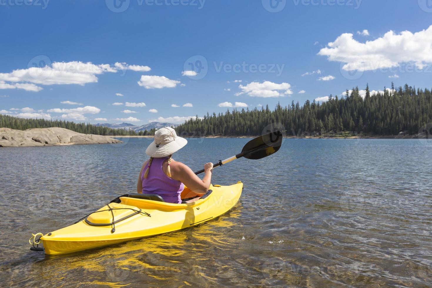 kvinna som paddlar på den vackra bergsjön. foto