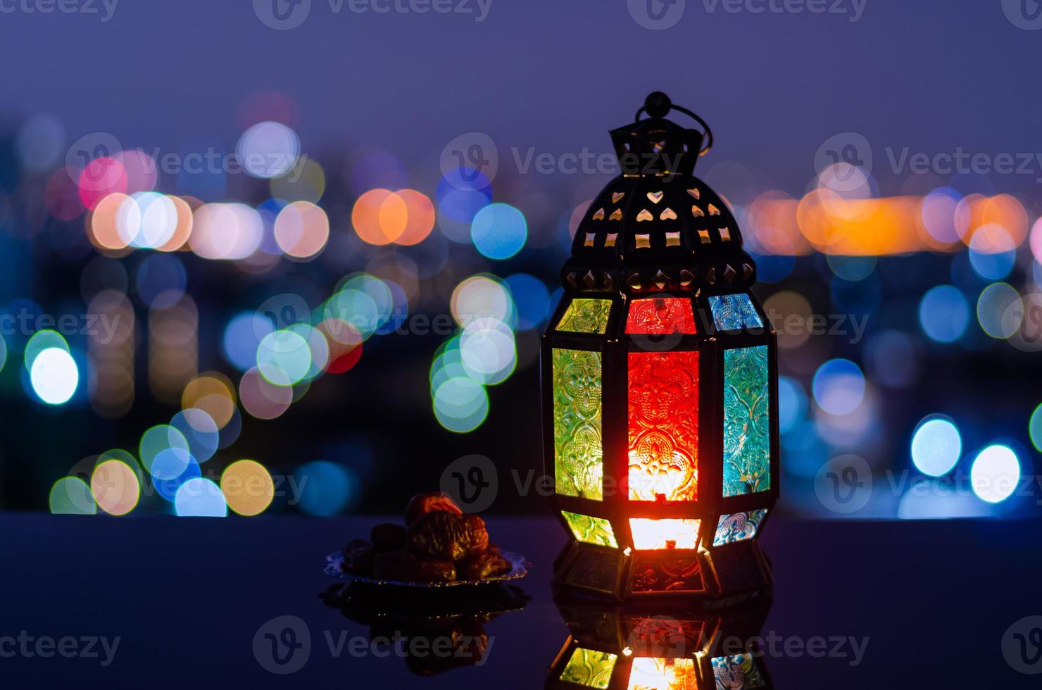 lykta och små tallrik av datum frukt med stad bokeh ljus bakgrund för de muslim fest av de helig månad av ramadan kareem. foto