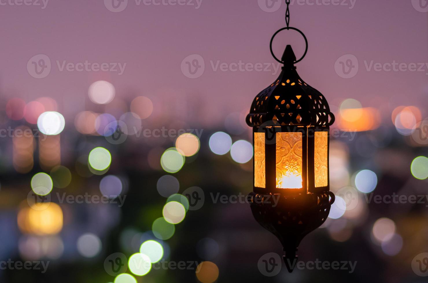 hängande lykta med natt himmel och stad bokeh ljus bakgrund för de muslim fest av de helig månad av ramadan kareem. foto