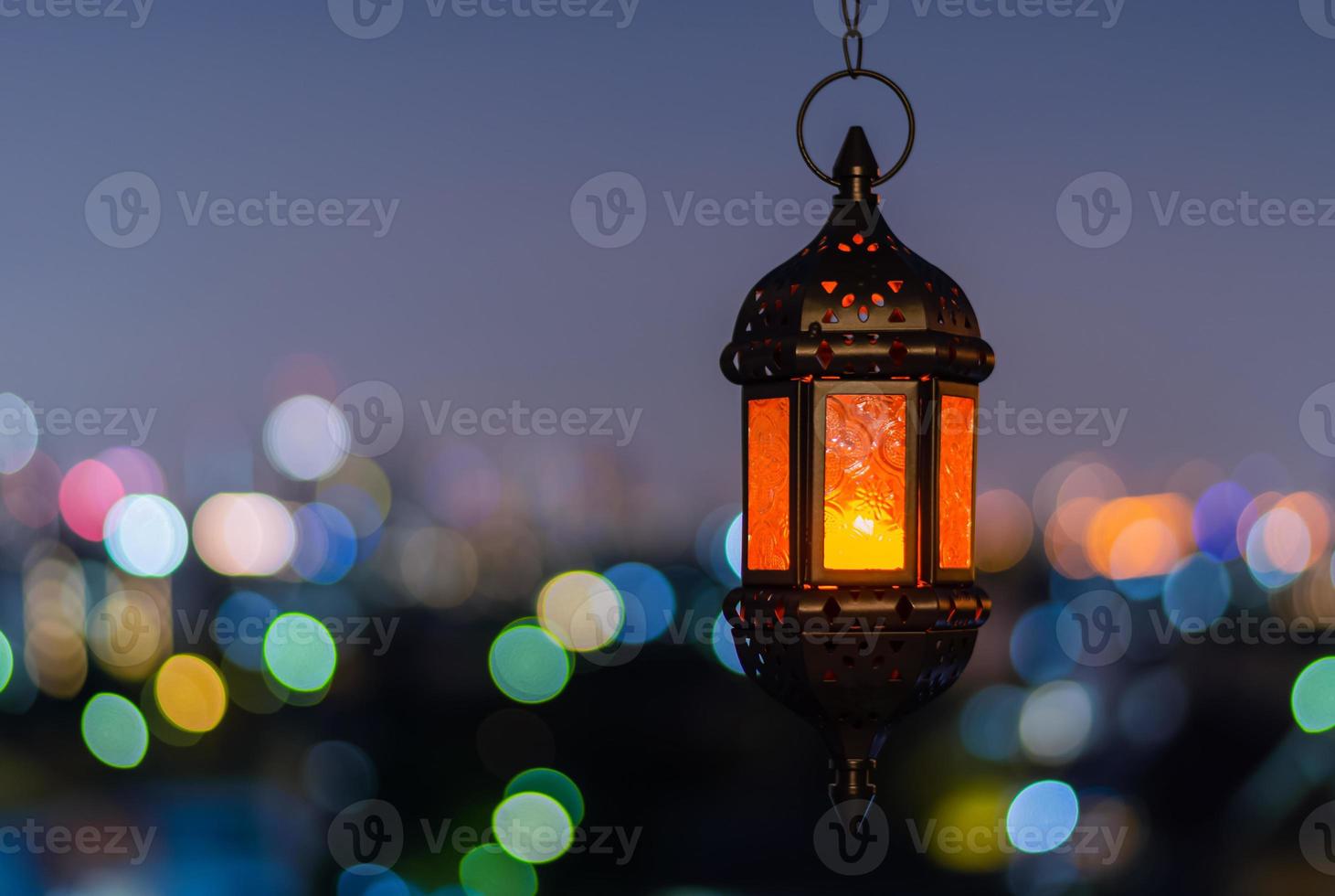 hängande lykta med natt himmel och stad bokeh ljus bakgrund för de muslim fest av de helig månad av ramadan kareem. foto