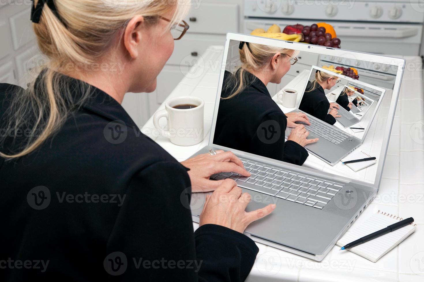 abstrakt av kvinna i kök använder sig av bärbar dator foto
