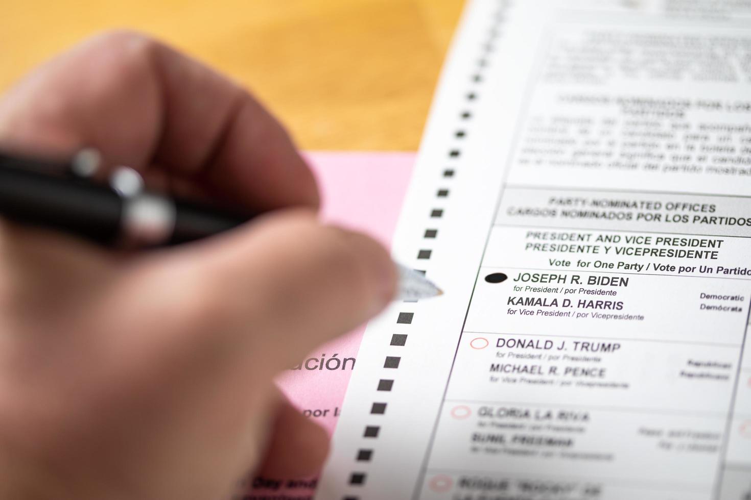 floden, Kalifornien, USA - 10, 2020 man fyllningar i joe biden röstning bubbla med penna på officiell valsedel i de 2020 president- val foto
