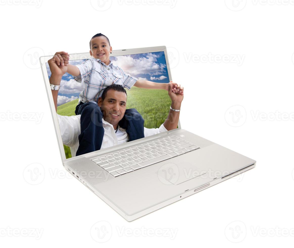 Lycklig latinamerikan far och son i bärbar dator skärm foto