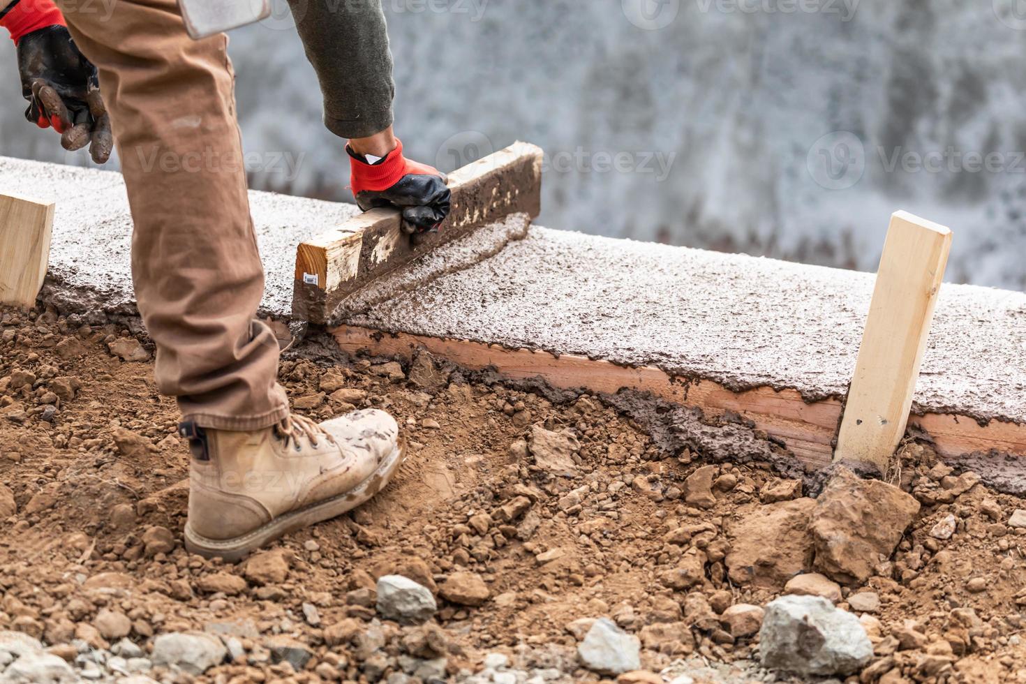 konstruktion arbetstagare utjämning våt cement in i trä inramning foto