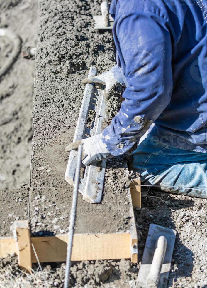 slå samman konstruktion arbetstagare arbetssätt med en smidigare stång på våt betong foto