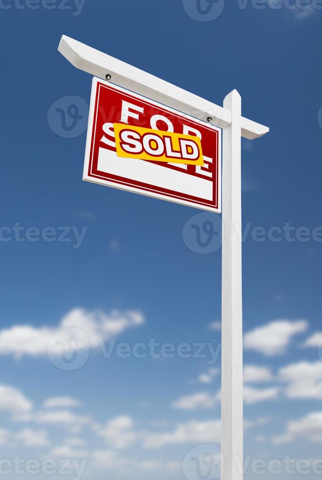 vänster vänd såld för försäljning verklig egendom tecken på en blå himmel med moln. foto