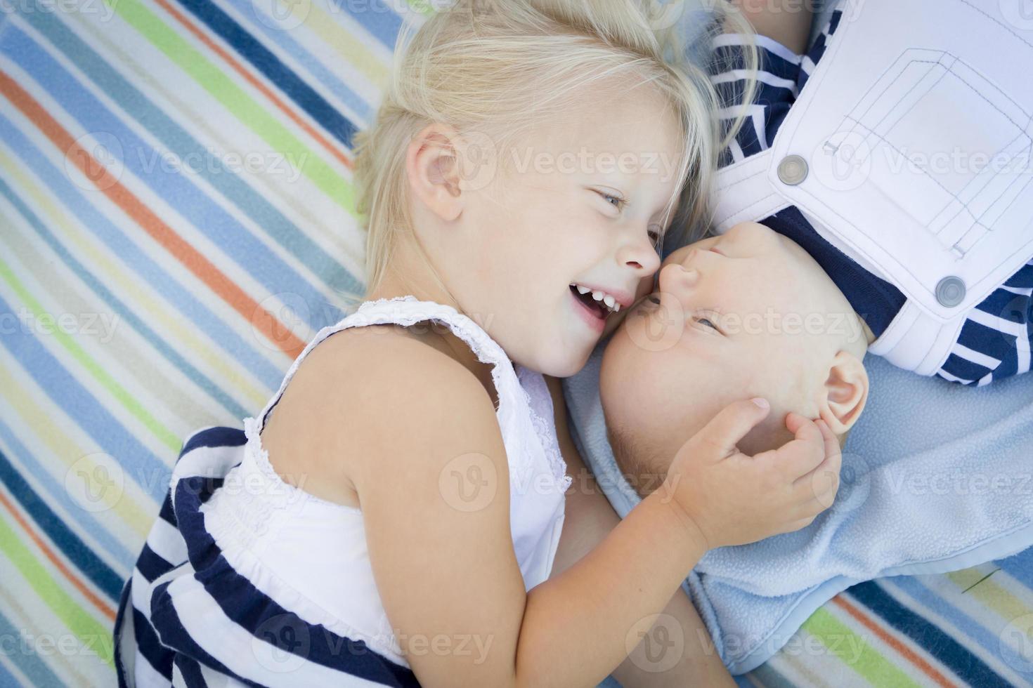 liten syster om Nästa till henne bebis bror på filt foto