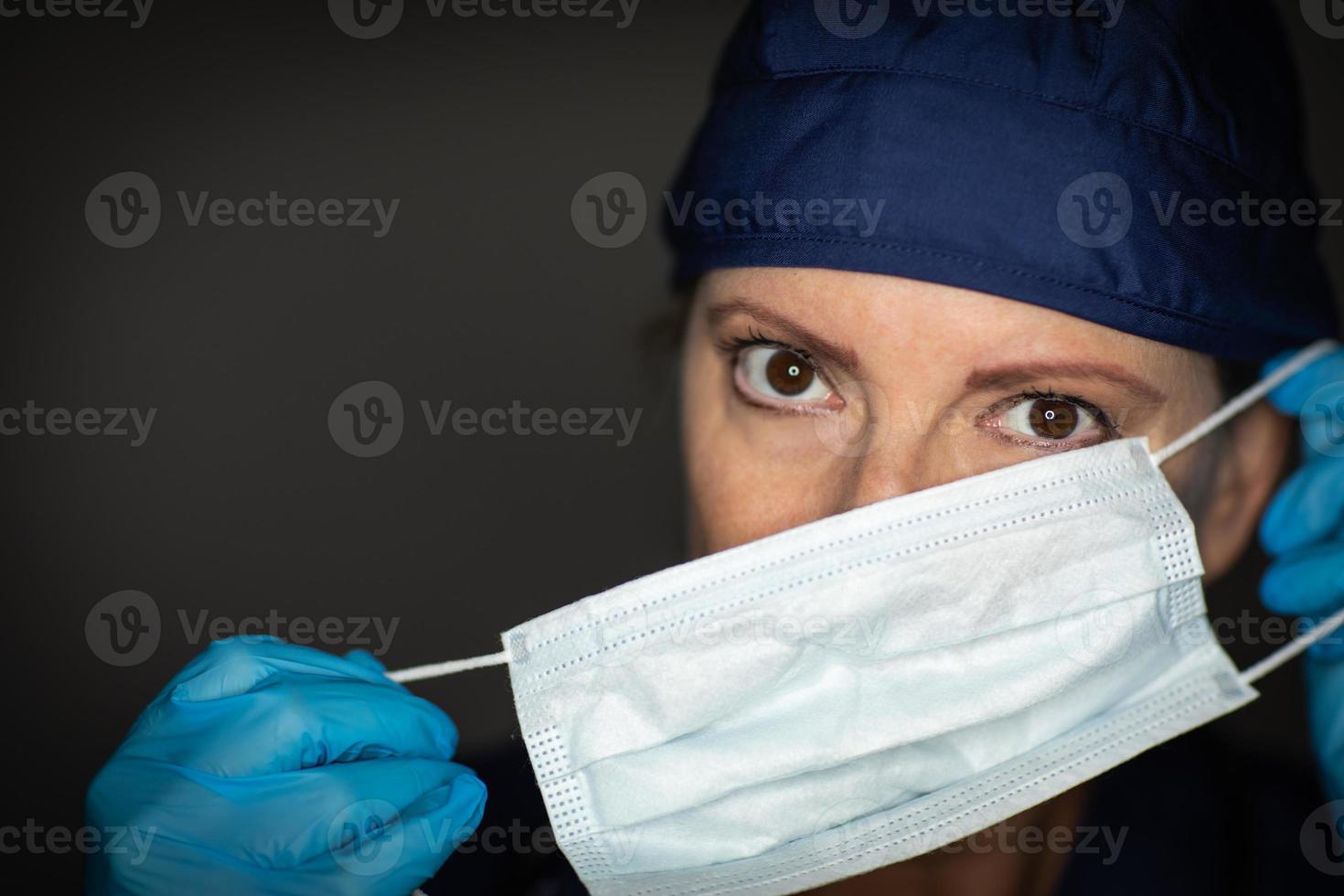 kvinna läkare eller sjuksköterska bär kirurgisk handskar sätta på medicinsk ansikte mask foto
