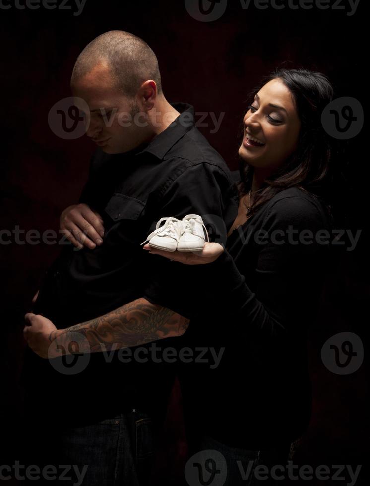 blandad lopp par innehav ny vit bebis skor på svart foto