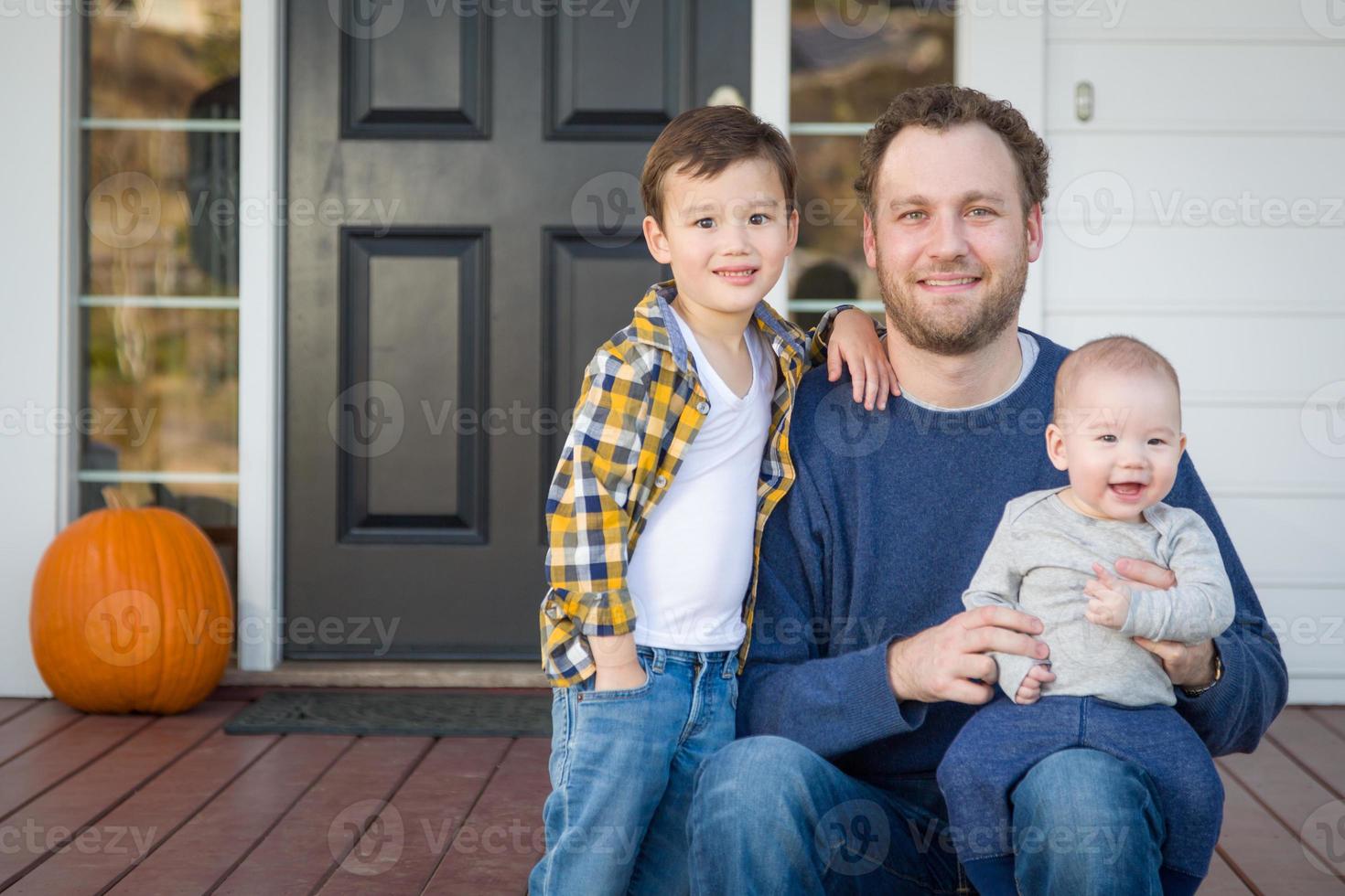 blandad lopp far och söner på främre veranda foto