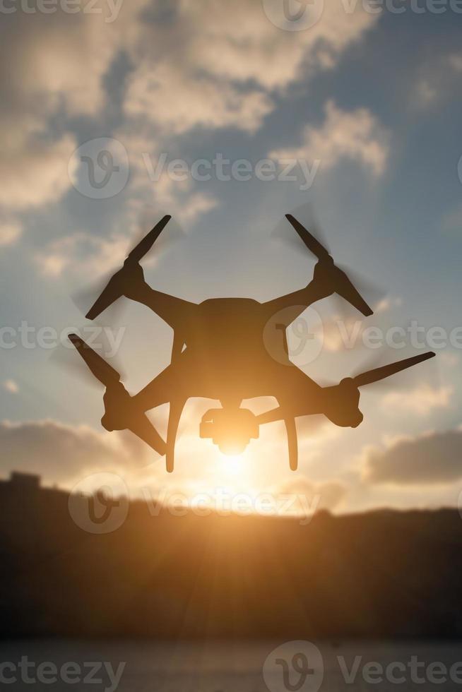 silhuett av obemannad flygplan systemet uav quadcopter Drönare i de luft på soluppgång. foto