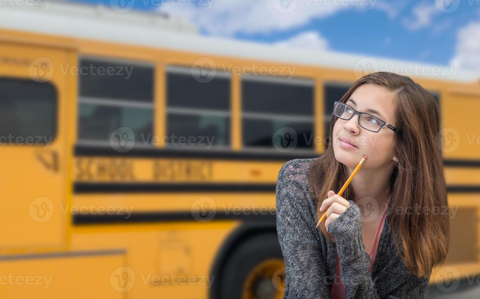 ung kvinna studerande nära skola buss foto