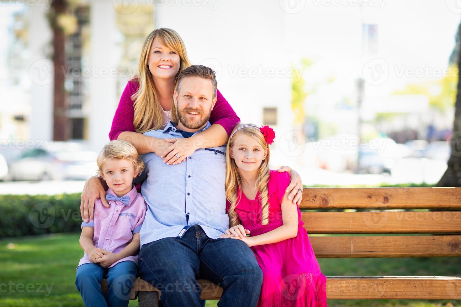 Lycklig attraktiv ung caucasian familj porträtt i de parkera foto