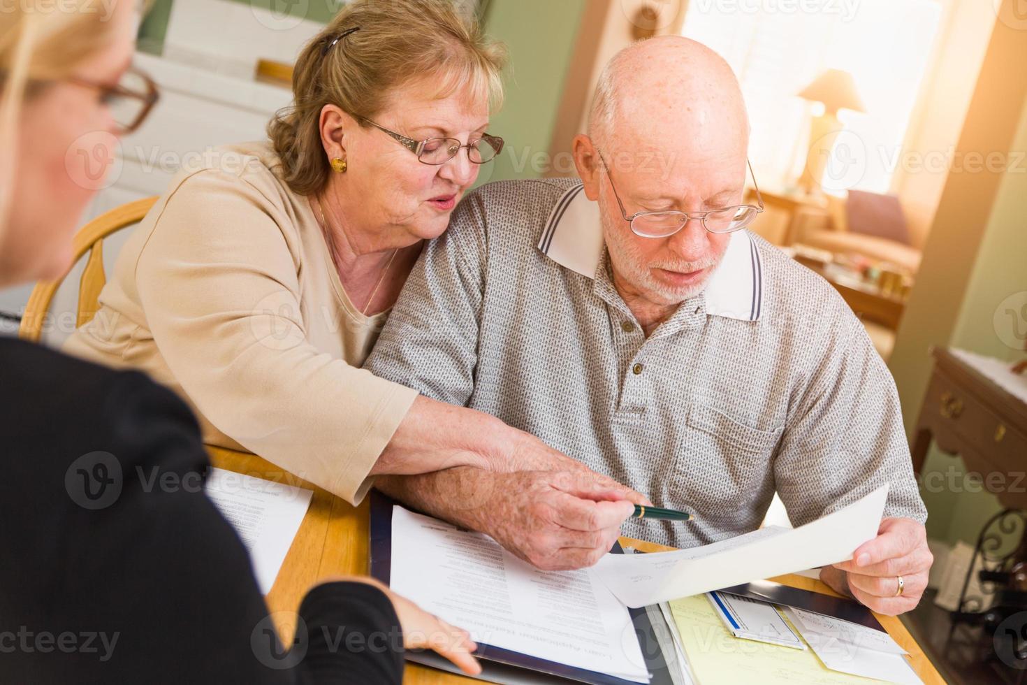 senior vuxen par gående över dokument i deras Hem med ombud på signering foto