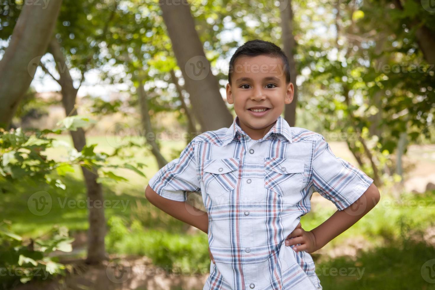 stilig ung latinamerikan pojke i de parkera foto