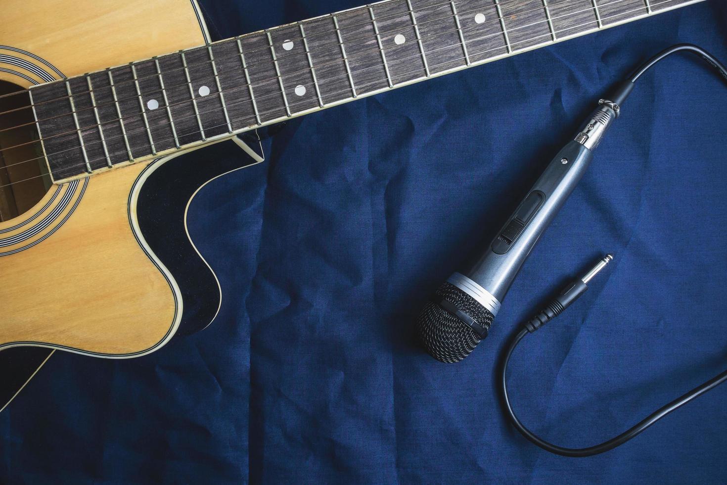 mikrofon och akustisk gitarr på bordet foto