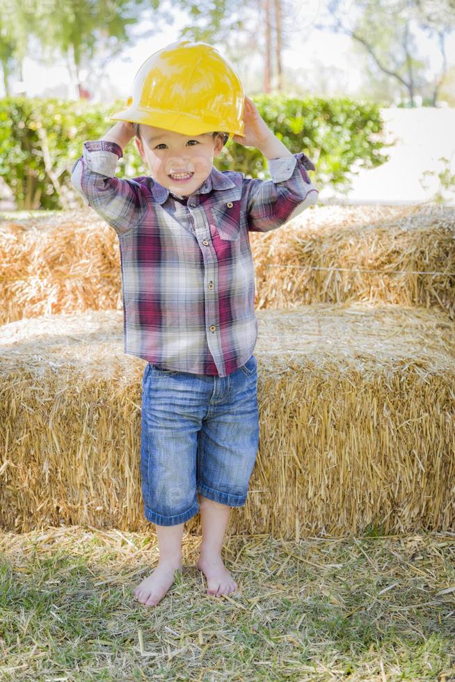 ung blandad lopp pojke skrattande med hård hatt utanför foto