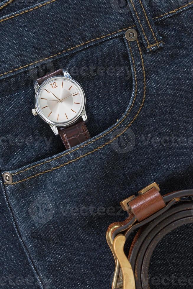 armbandsur och läderbälte på jeans foto