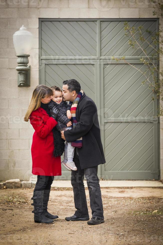 varmt klädd familj kärleksfull son i främre av rustik byggnad foto