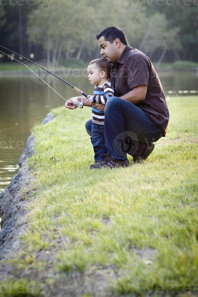 Lycklig ung etnisk far och son fiske foto