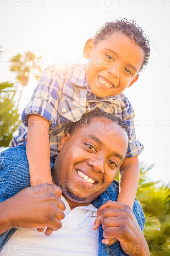 blandad lopp son och afrikansk amerikan far spelar piggyback utomhus tillsammans. foto