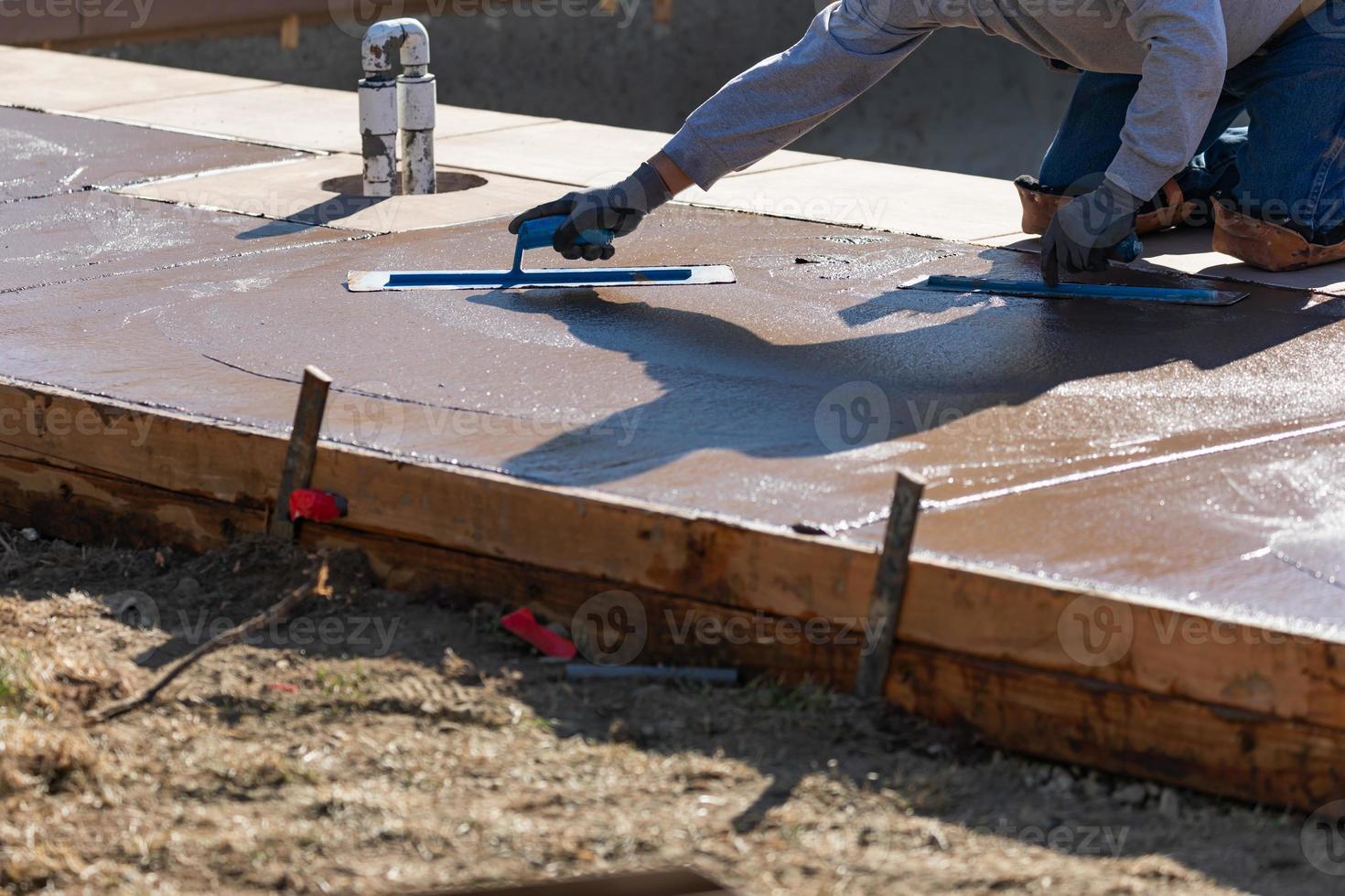 konstruktion arbetstagare glättning våt cement med murslev verktyg foto