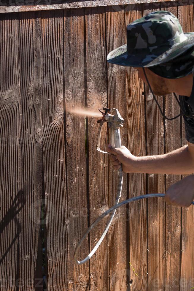 professionell målare besprutning gård staket med färga foto