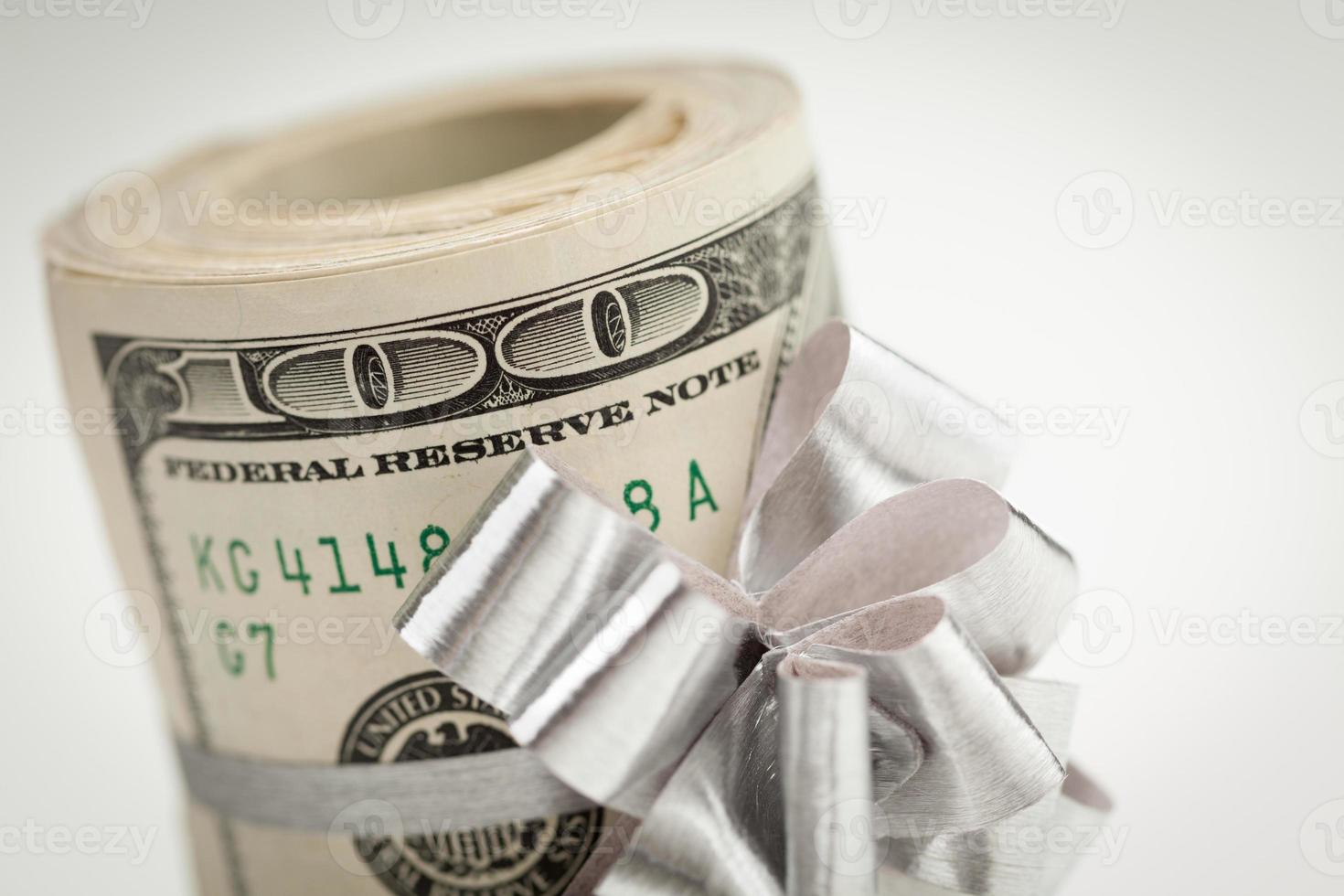 rulla av ett hundra dollar räkningar med silver- rosett på vit foto