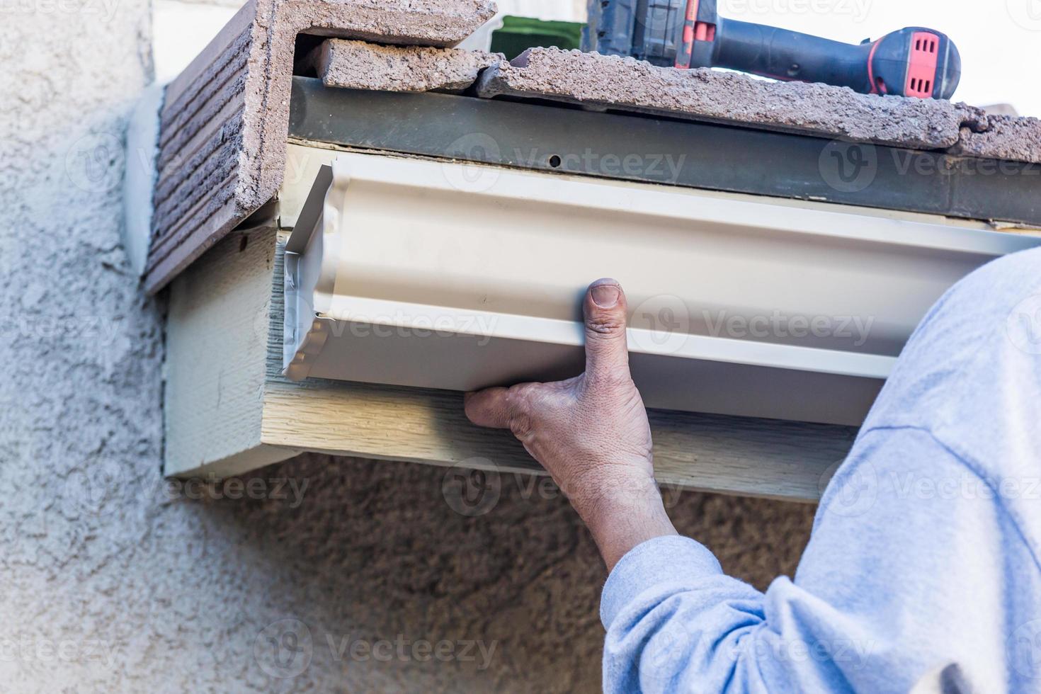 arbetstagare fastsättnings aluminium regn ränna till fascia av hus foto