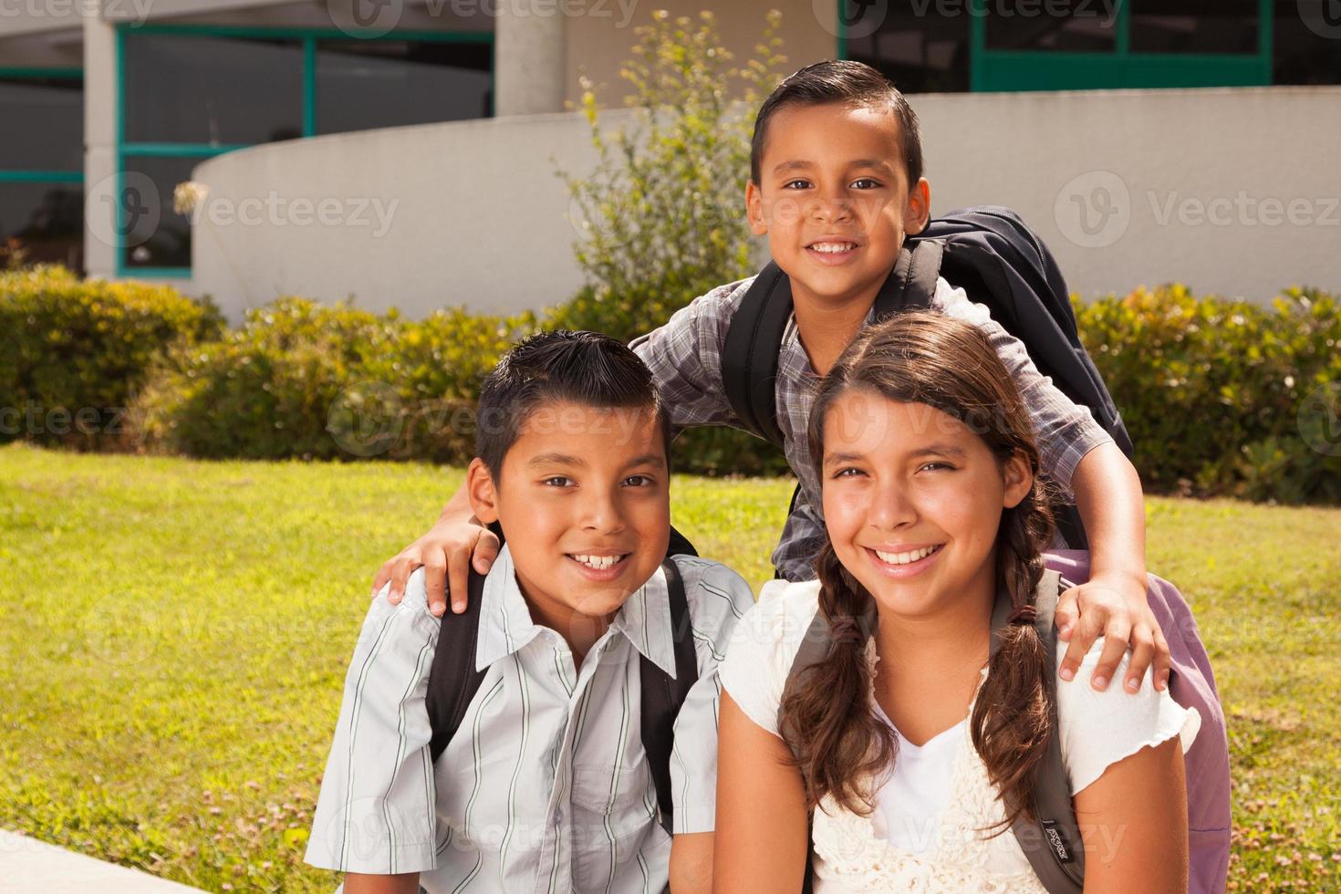 ung latinamerikan studerande barn bär ryggsäckar på skola campus foto