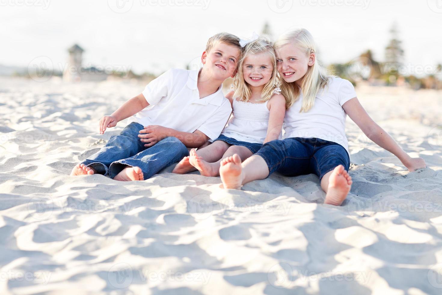 förtjusande systrar och bror har roligt på de strand foto