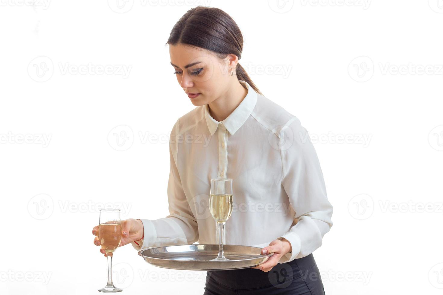 allvarlig ung servitris i enhetlig med glasögon av vin i händer foto