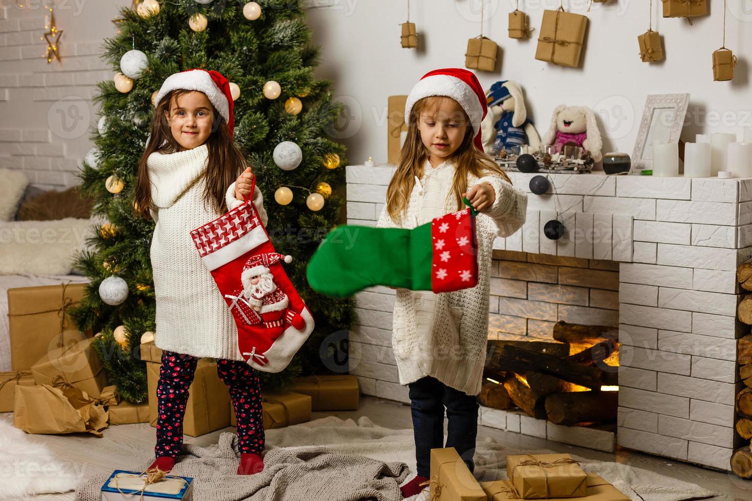 två liten flickor delning en överraskning på jul morgon- foto