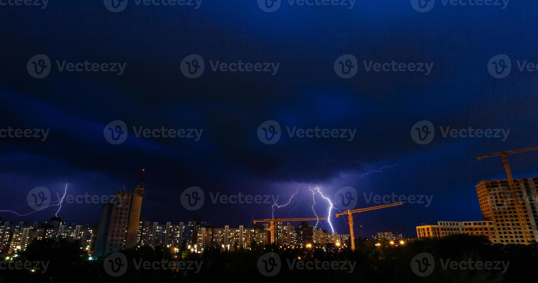 storm och belysning över hus. åskväder på natt nära by. foto