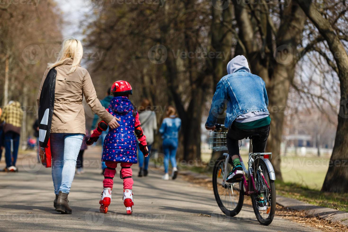 caucasian kvinna lär henne dotter till skridsko på vält skridskor foto