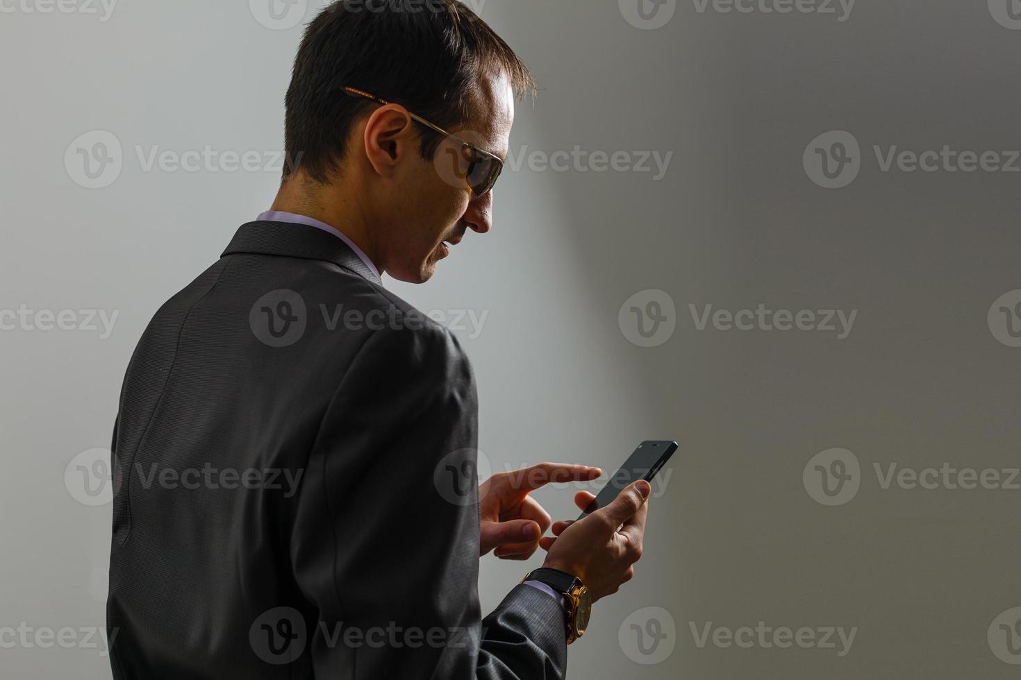 leende ung mitten östra man med smartphone foto