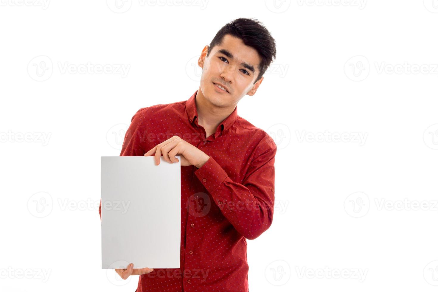 elegans ung kille i röd t-shirt med tömma plakat ser på de kamera isolerat på vit bakgrund foto