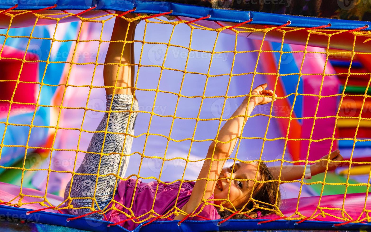 liten barn Hoppar på trampolin i inomhus lekplats. aktiva litet barn flicka har roligt på sport Centrum foto