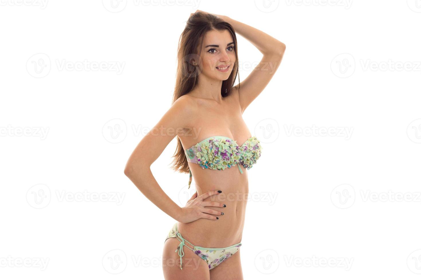 glad ung kvinna med stor naturlig tuttar i baddräkt med blommig mönster Framställ och leende isolerat på vit bakgrund foto