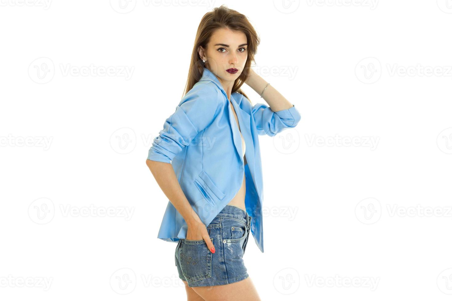 skön kvinna i blå jacka utan underkläder utseende på de kamera foto