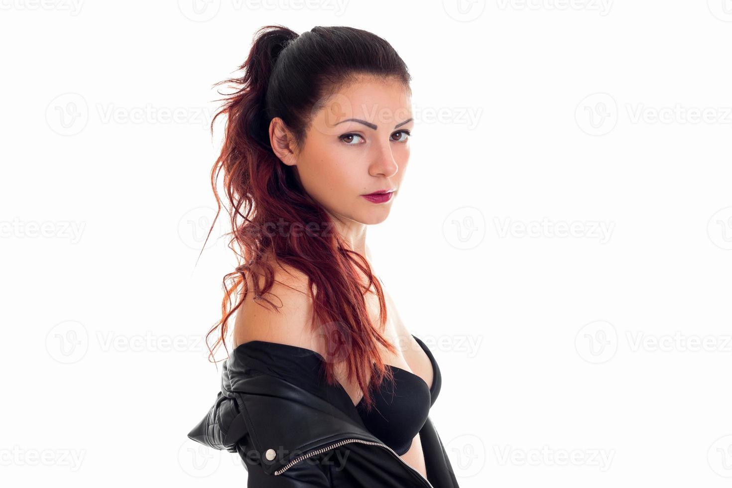 stänga upp porträtt av skön kvinna på svart behå och läder jacka Framställ på kamera foto