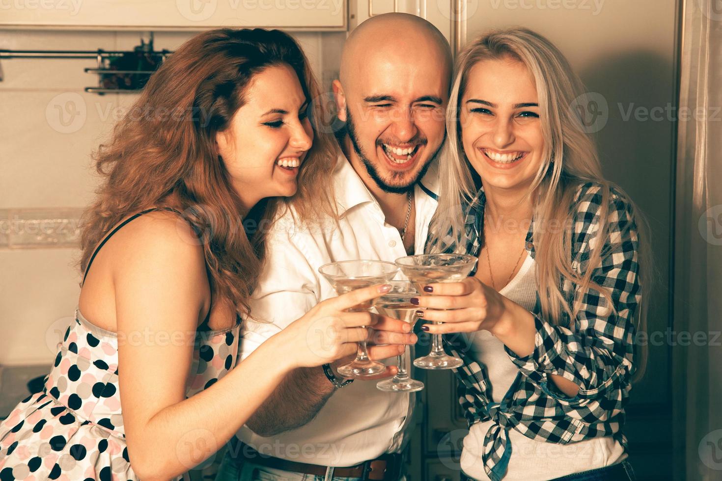 par av skön damer har roligt med en kille på en fest med en glas av Martini foto