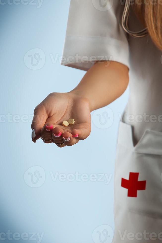 sjuksköterska innehav en piller i handflatan foto