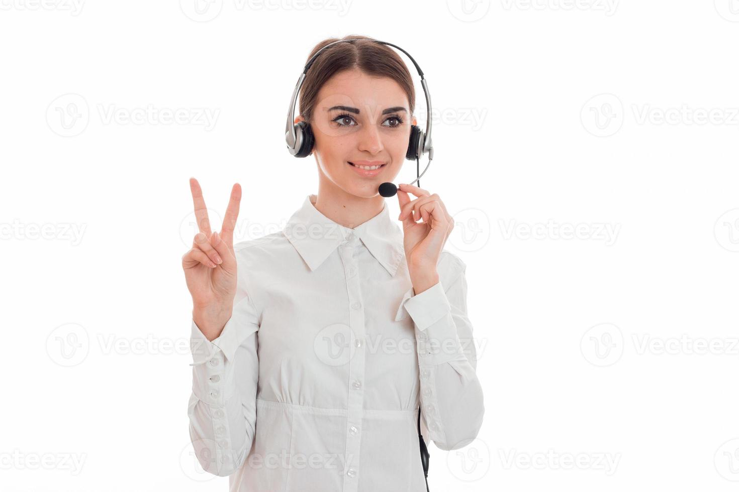 horisontell porträtt av ung glad ring upp kontor arbetstagare flicka med hörlurar och mikrofon isolerat på vit bakgrund foto