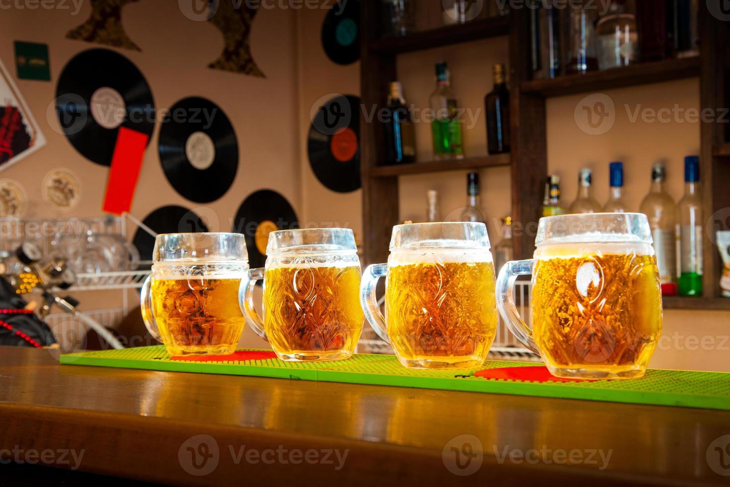 fyra glasögon av öl stå i en rad på de bar tabell foto